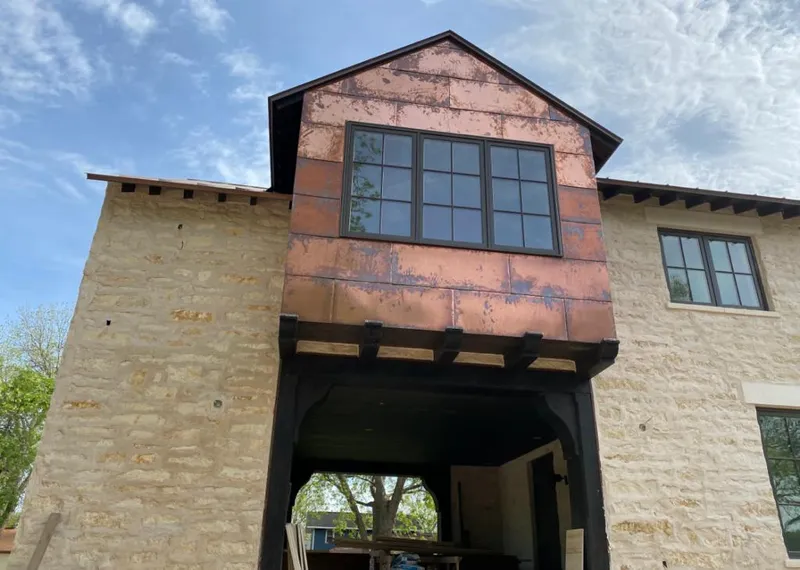Copper metal panel facade on a stone building for Roof Repair in Chesapeake Ranch Estates